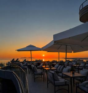 a restaurant with tables and chairs with the sunset in the background at Hotel Albsin in Vlorë +9 photos