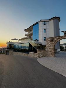 a building with a stone wall in front of it at Hotel Albsin in Vlorë