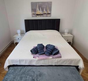a bed with two blue pillows on top of it at Apartmani Božica in Jadranovo