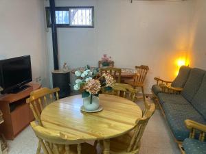a living room with a table with a vase of flowers at Habitación privada con zonas compartidas in Castellbisbal