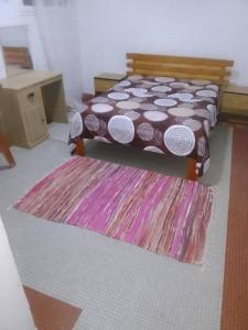 a bedroom with a bed and a rug at Paradise maison d'hôte in Nouakchott +1 photo