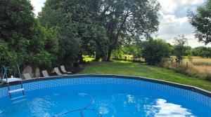 a swimming pool in a yard with chairs and trees at Piscine - Domaine de Wolphus - 15 min de la mer in Zouafques