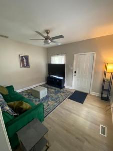 a living room with a green couch and a flat screen tv at The Heart house in Indianapolis
