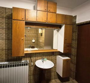 a bathroom with a sink and wooden cabinets at Apartmani Božica in Jadranovo +31 photos