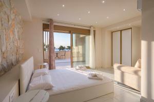 a bedroom with a bed and a view of the ocean at The Serata Villas 2 in Hanioti