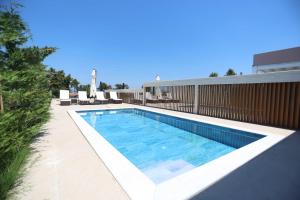 a swimming pool on the side of a building at The Serata Villas 2 in Hanioti +38 photos