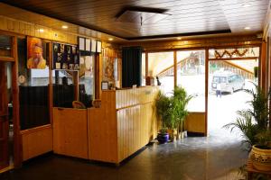 a restaurant with a counter in a building at Hotel Mid Orchard Kasol -River Side in Kasol