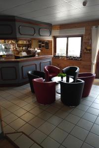 a restaurant with chairs and a table and a counter at Hôtel Restaurant Ardesia in Peyrelevade
