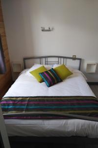 a bed with two pillows and a blanket on it at Hôtel Restaurant Ardesia in Peyrelevade