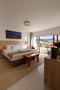 a bedroom with a king sized bed and a table at Baños del Inca Premium Hotel in Los Baños del Inca