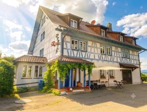 a large white building with a table in front of it at Pension Rose-Monteurzimmer & Ferienzimmer - Bodensee-Selbstversorger mit Küchen, Parken & Kaffee & Wlan frei in Ravensburg
