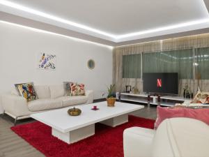 a living room with a white couch and a red rug at Atlas - Appartement moderne in Fez