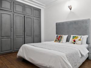 a bedroom with two beds and a gray cabinet at Atlas - Appartement moderne in Fez