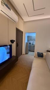 a living room with a couch and a flat screen tv at استديو فندقي دخول ذكي عائلي مريح in Al Ahsa