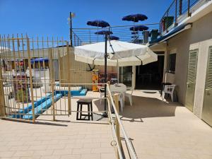 a patio with a playground with an umbrella and a slide at Casa Caribe - Piscina, Spiaggia e Parcheggio inclusi! GRATIS in Sanremo