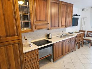 a kitchen with wooden cabinets and a sink at Casa Caribe - Piscina, Spiaggia e Parcheggio inclusi! GRATIS in Sanremo +34 photos