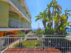 a building with a fence next to the beach at Casa Caribe - Piscina, Spiaggia e Parcheggio inclusi! GRATIS in Sanremo