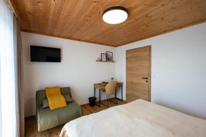 a bedroom with a bed and a chair and a television at Ferienwohnung Tiefengraber in Weiz