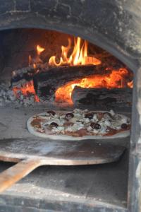 a pizza is being cooked in an oven at Vila Stancevic wellness in Sremski Karlovci