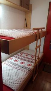 a bedroom with two bunk beds with a patterned rug at Charmant Studio La Toussuire in La Toussuire