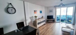 a living room with a clock on the wall at Le vitrail d'Arcachon - Appt Spacieux Terrasse Ménage draps inclus in Arcachon