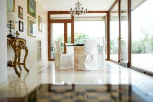a living room with a table and chairs and windows at VillaCycas in Casal Taulero