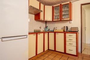 a kitchen with wooden cabinets and a refrigerator at Chalupa U lesa in Karlova Studánka +17 photos