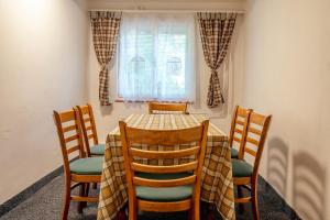 a dining room table with four chairs and a window at Chalupa U lesa in Karlova Studánka