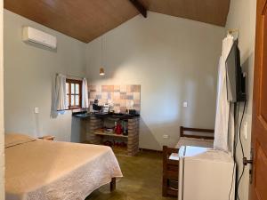 a room with a bed and a tv in it at Vila Clara do Capão in Vale do Capao