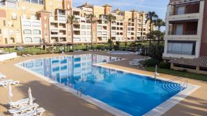 an overhead view of a swimming pool with chairs and buildings at Beachfront Apartment - Sea View - COU02 in Ayamonte