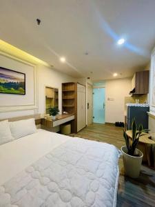 a bedroom with a large white bed and a kitchen at Sencoco Hotel in Hà Quảng (4)