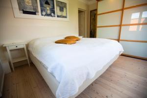 a large white bed with a brown blanket on it at Luxurious, spacious apartment - Nordic Style in Copenhagen