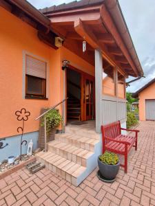 a red bench sitting in front of a house at Ferienwohnung am Keltenwall in Jestetten