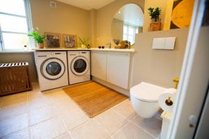 a bathroom with a washing machine and a toilet at Luxurious, spacious apartment - Nordic Style in Copenhagen