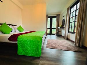 a bedroom with a bed with a green comforter at The Urban Hideout in Nuwara Eliya