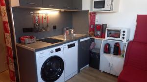 a small kitchen with a washing machine and a sink at Charmant Studio La Toussuire in La Toussuire