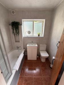 a bathroom with a tub and a toilet and a sink at Stay at 48 in Oulton +19 photos