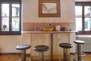 a bar with stools in a kitchen with windows at Casa Alighieri 2 in Levanto +9 photos