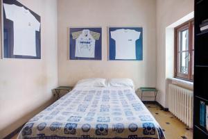 a bedroom with a bed with two pictures on the wall at Casa Alighieri 2 in Levanto