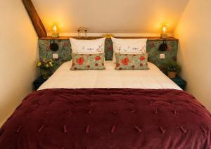 a bedroom with a large bed with red comforter and pillows at Villa Piscine et Jaccuzzi - Vue Panoramique in Juillac