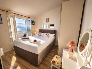 a bedroom with a large bed with a large window at Apartman Štorija with Private Jacuzzi-Brela in Brela