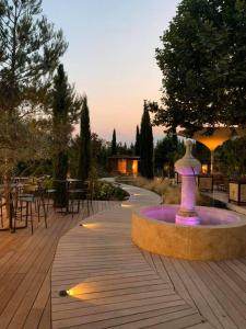 a fountain in a park with tables and chairs at La Villa Saint-Antoine in Violès