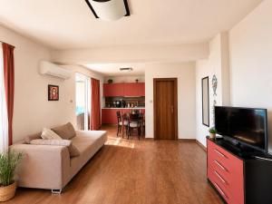 a living room with a couch and a flat screen tv at Villa Smokinya in Sozopol