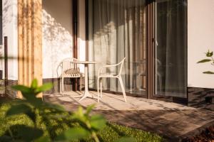 two white chairs and a table on a balcony at Baltic Season Spa Apartments in Grzybowo