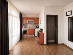 a kitchen with orange cabinets and a wooden floor at Villa Smokinya in Sozopol