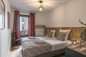 a hotel room with two beds and a window at Canopee 206 - by Care Concierge in Saint-Gervais-les-Bains +13 photos