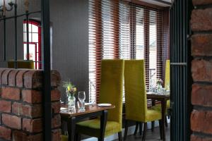 a dining room with two tables and yellow chairs at Barton Manor Hotel & Spa, BW Signature Collection in Preston