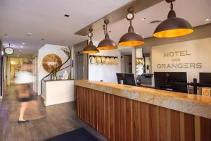 a woman walking past a hotel lobby with a bar at Best Western Hôtel des Orangers Cannes in Cannes +101 photos