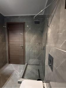a bathroom with a shower with a glass door at Royal Vinea Suites in Elevtheraí +37 photos