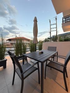 a wooden table and two chairs on a patio at Royal Vinea Suites in Elevtheraí